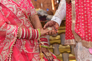Close-up of a colorful Indian wedding ceremony featuring intricate henna designs and traditional attire.