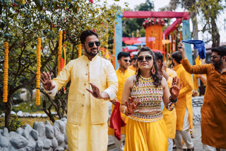 Colorful Indian wedding celebration with people in traditional attire outside.