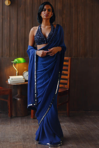 Blue designer saree with intricate embellishments draped on a mannequin or model, highlighting gradient tones and luxurious detailing.