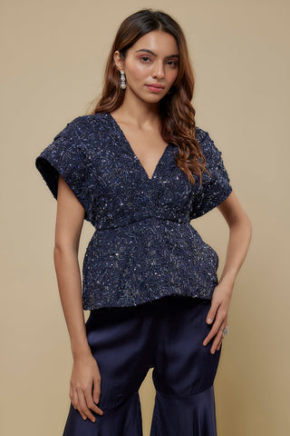 Waist-up view of the navy V-neck peplum top with abstract floral beads and sequins by Asaga at Mrs. G