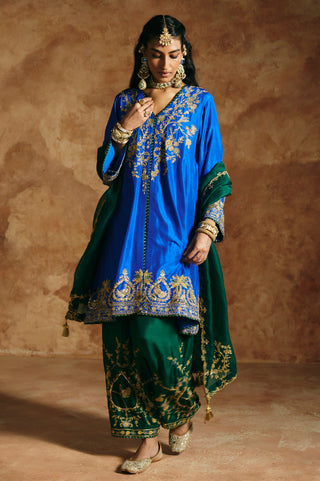 Three-quarter view of the cobalt blue kurta's gold floral yoke and wide hem band by Aman Takyar at Mrs. G