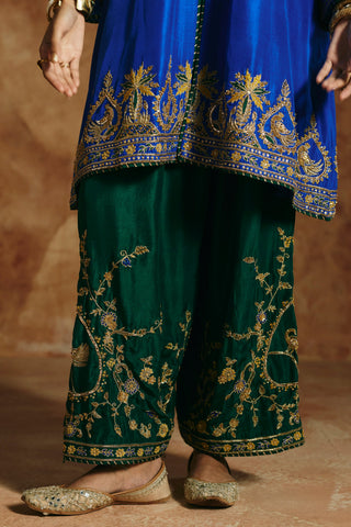 Close-up of the deep green pants with trailing gold floral vines beneath the kurta's hem band by Aman Takyar at Mrs. G