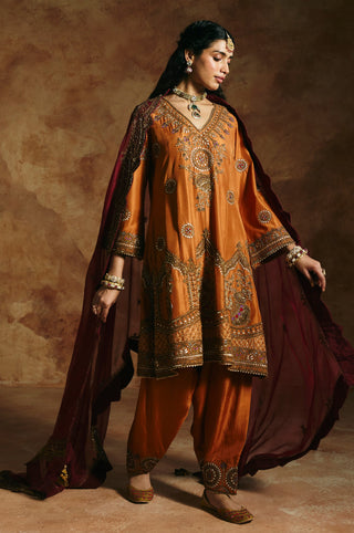 Walking view of the rust kurta set with the maroon dupatta trailing behind by Aman Takyar at Mrs. G
