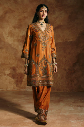 Front view of the rust V-neck kurta with its embroidered hem border and gathered pants by Aman Takyar at Mrs. G