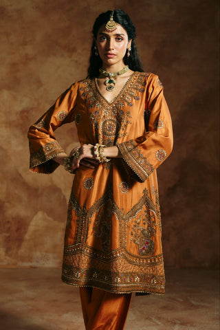 Waist-up view of the rust kurta's V-neckline embroidered with a floral medallion by Aman Takyar at Mrs. G