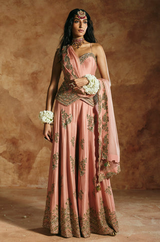 Front view of the onion pink sharara set with white flower bracelets and the dupatta draped across by Aman Takyar at Mrs. G