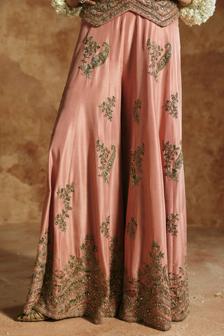 Close-up of the onion pink sharara's paisley and leaf motifs and embroidered hem border by Aman Takyar at Mrs. G