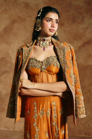 Waist-up view of the orange notched-collar jacket and corset above embroidered sharara motifs by Aman Takyar at Mrs. G