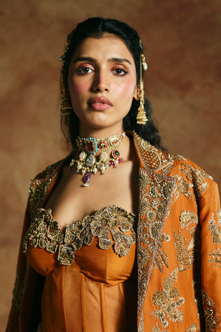 Close-up of the orange corset's embroidered sweetheart neckline and the jacket's notched collar by Aman Takyar at Mrs. G