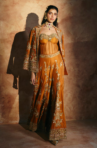 Front view of the orange set with the jacket worn open over the sheer-paneled corset by Aman Takyar at Mrs. G