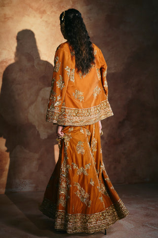Back view of the orange jacket's embroidered hem above the flared sharara in motion by Aman Takyar at Mrs. G