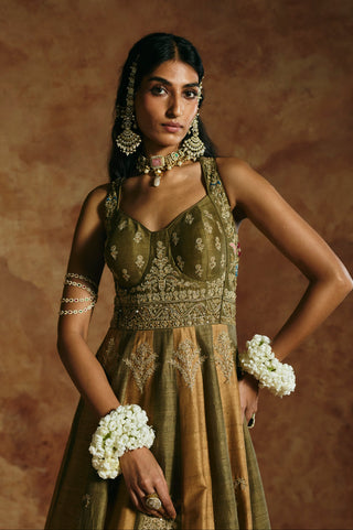 Waist-up view of the green rust anarkali set with hand on hip showing the embroidered waistband by Aman Takyar at Mrs. G