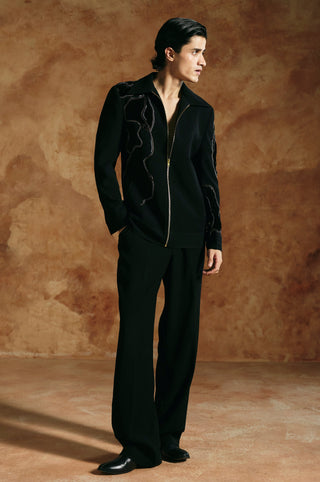 Side-facing full-length view of the black zipper jacket with hand in pocket by Aman Takyar at Mrs. G