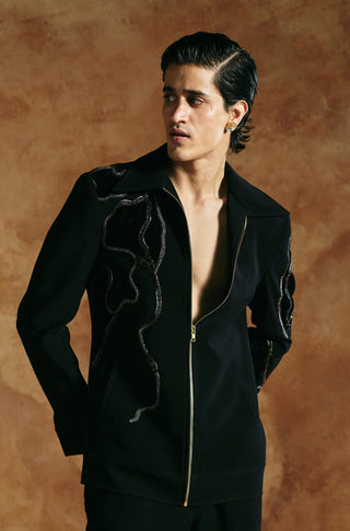 Front view of the black zipper jacket worn partly open with hand behind the back by Aman Takyar at Mrs. G
