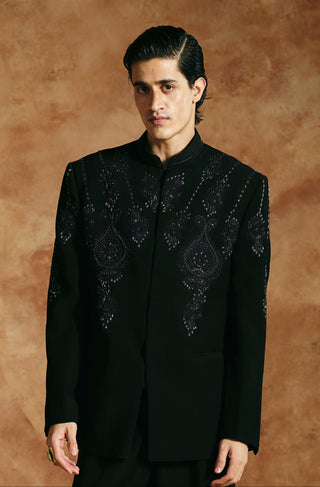 Full-length front view of the black bandhgala set with straight trousers and hand by the side by Aman Takyar at Mrs. G