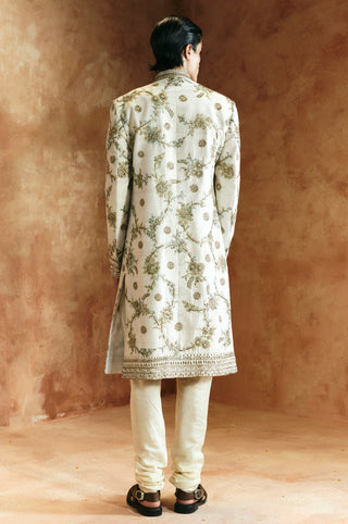 Back view of the ivory sherwani set with vine embroidery and a beaded hem border by Aman Takyar at Mrs. G