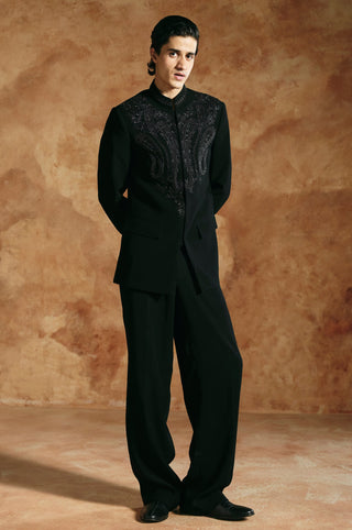 Three-quarter front view of the black bandhgala with a mandarin collar and trousers by Aman Takyar at Mrs. G