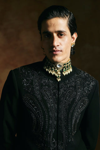 Close-up of the black bandhgala collar and paisley yoke styled with a jeweled choker by Aman Takyar at Mrs. G