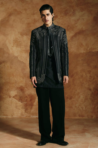 Front view of the black jacket with silver beaded vertical stripes and a stand collar by Aman Takyar at Mrs. G