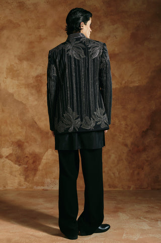 Back view of the black striped jacket with palm leaves at the shoulders and hem by Aman Takyar at Mrs. G