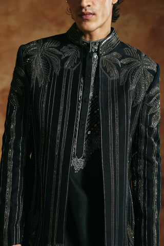 Close-up of the black jacket front with vertical beadwork lines and the embroidered collar by Aman Takyar at Mrs. G