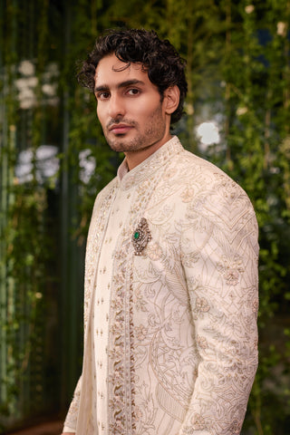 Three-quarter view of the ivory silk sherwani with tonal resham embroidery and mandarin collar by Jigar and Nikita at Mrs. G