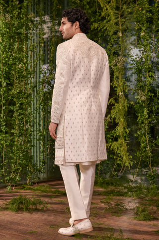 Back view of the ivory sherwani with butta embroidery and paisley hem border by Jigar and Nikita at Mrs. G