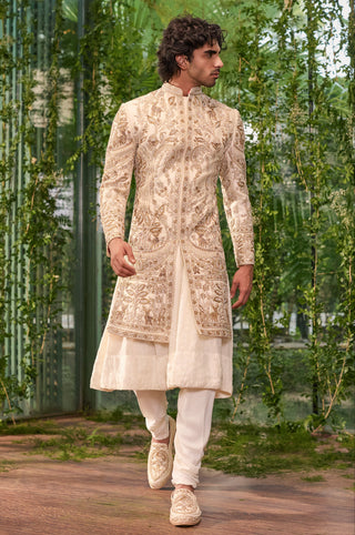 Walking view of the ivory cluster sherwani over an anarkali kurta and satin trousers by Jigar and Nikita at Mrs. G