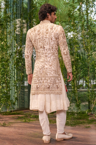 Back view of the sherwani with all-over gold floral vines and deer motif and hem border by Jigar and Nikita at Mrs. G
