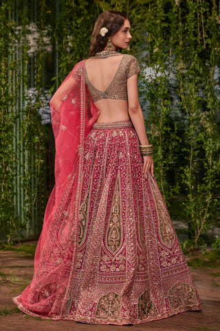 Full-length back view of the pink lehenga with deep V blouse back and appliqué skirt panels by Jigar and Nikita at Mrs. G