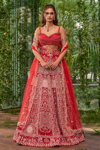Full-length front view of the vermillion lehenga set with pearl-wrapped blouse and tulle dupatta by Jigar and Nikita at Mrs. G