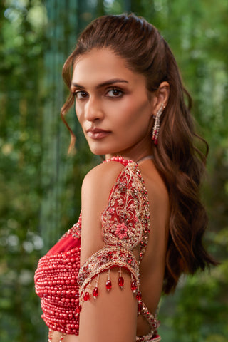 Side view of the pearl blouse with embroidered arm cuff, ruby-red drops and open back by Jigar and Nikita at Mrs. G