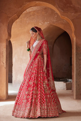 Red tarana vibrant raw silk lehenga set by Nikita Gujral at Mrs. G