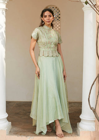 Three-quarter view of frost blue scalloped peplum top and asymmetrical skirt by Osaa by Adarsh at Mrs. G