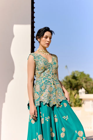 Three-quarter view of pine green peplum top with gold zardozi and a flared garara by Osaa by Adarsh at Mrs. G