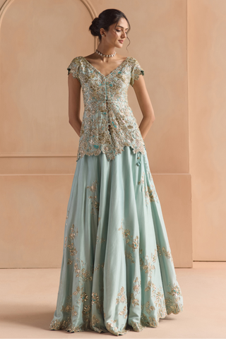 Three-quarter view of teal peplum jacket lehenga with scattered gold flower motifs on the skirt by Osaa by Adarsh at Mrs. G
