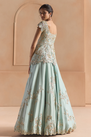 Back view of teal peplum jacket with scoop back and A-line lehenga with scalloped sequin hem by Osaa by Adarsh at Mrs. G