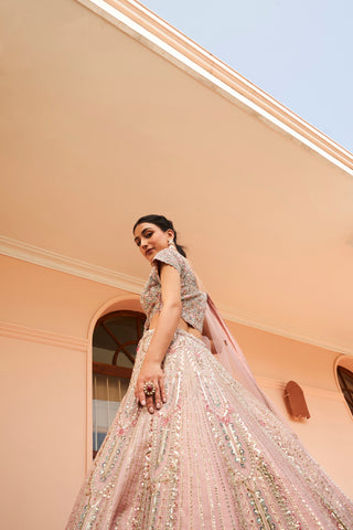 Low-angle side view of soft berry cap-sleeve blouse and paisley zardozi lehenga skirt by Osaa by Adarsh at Mrs. G
