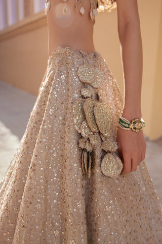 Close-up of beige champagne lehenga waist with leaf-shaped medallion latkan by Osaa by Adarsh at Mrs. G