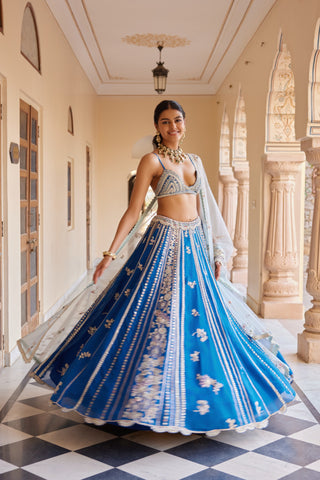 Twirling view of jade blue paneled lehenga with scalloped hem and tulle dupatta by Osaa by Adarsh at Mrs. G