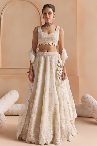 Front view of ivory lehenga set with sweetheart blouse, tulle dupatta and embroidered skirt by Osaa by Adarsh at Mrs. G