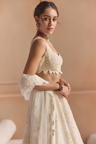 Side view of ivory tulle dupatta with scalloped lace border over the embroidered lehenga by Osaa by Adarsh at Mrs. G