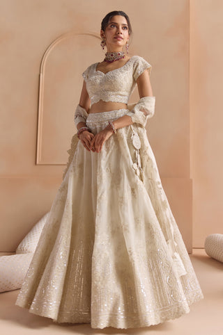 Front view of ivory lehenga set with tassel at the waist, tulle dupatta and embroidered skirt by Osaa by Adarsh at Mrs. G