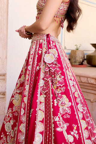 Side view of cut ruby lehenga waistband with a cluster of fabric flowers and beaded tassels by Osaa by Adarsh at Mrs. G