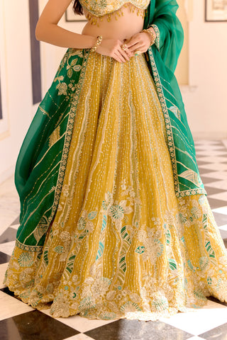 Close view of canary yellow skirt hem with cream flowers and teal leaf embroidery by Osaa by Adarsh at Mrs. G