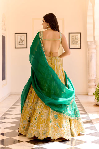 Back view of canary yellow lehenga with an open-back blouse and emerald dupatta by Osaa by Adarsh at Mrs. G