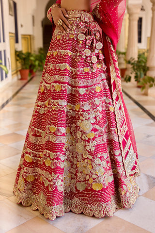 Close view of cut ruby lehenga skirt with flower tassels at the hip and layered scallop rows by Osaa by Adarsh at Mrs. G
