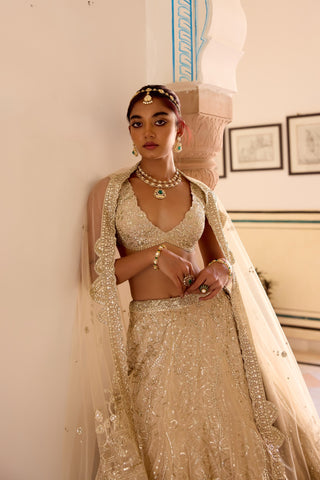 Three-quarter view of frost champagne V-neck blouse and jaal lehenga with scalloped dupatta by Osaa by Adarsh at Mrs. G