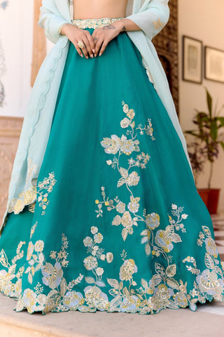 Close view of pine green lehenga skirt with cream and light blue floral vines at the hem by Osaa by Adarsh at Mrs. G
