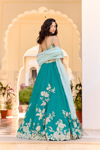Back view of pine green lehenga with thin-strap blouse and floral hem embroidery by Osaa by Adarsh at Mrs. G